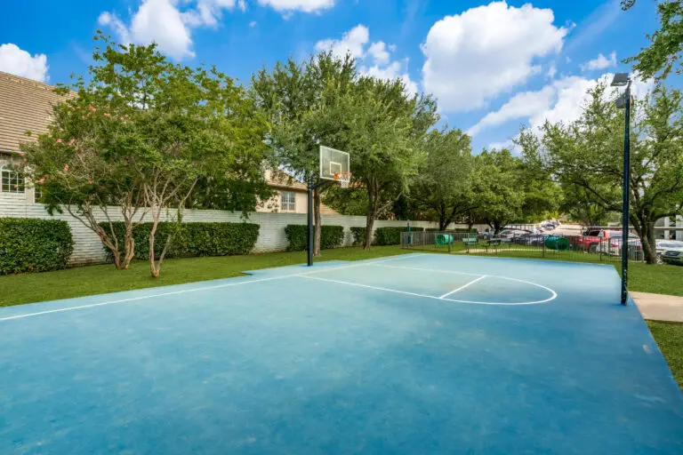 blue half court basketball flattop with outdoor lighting.