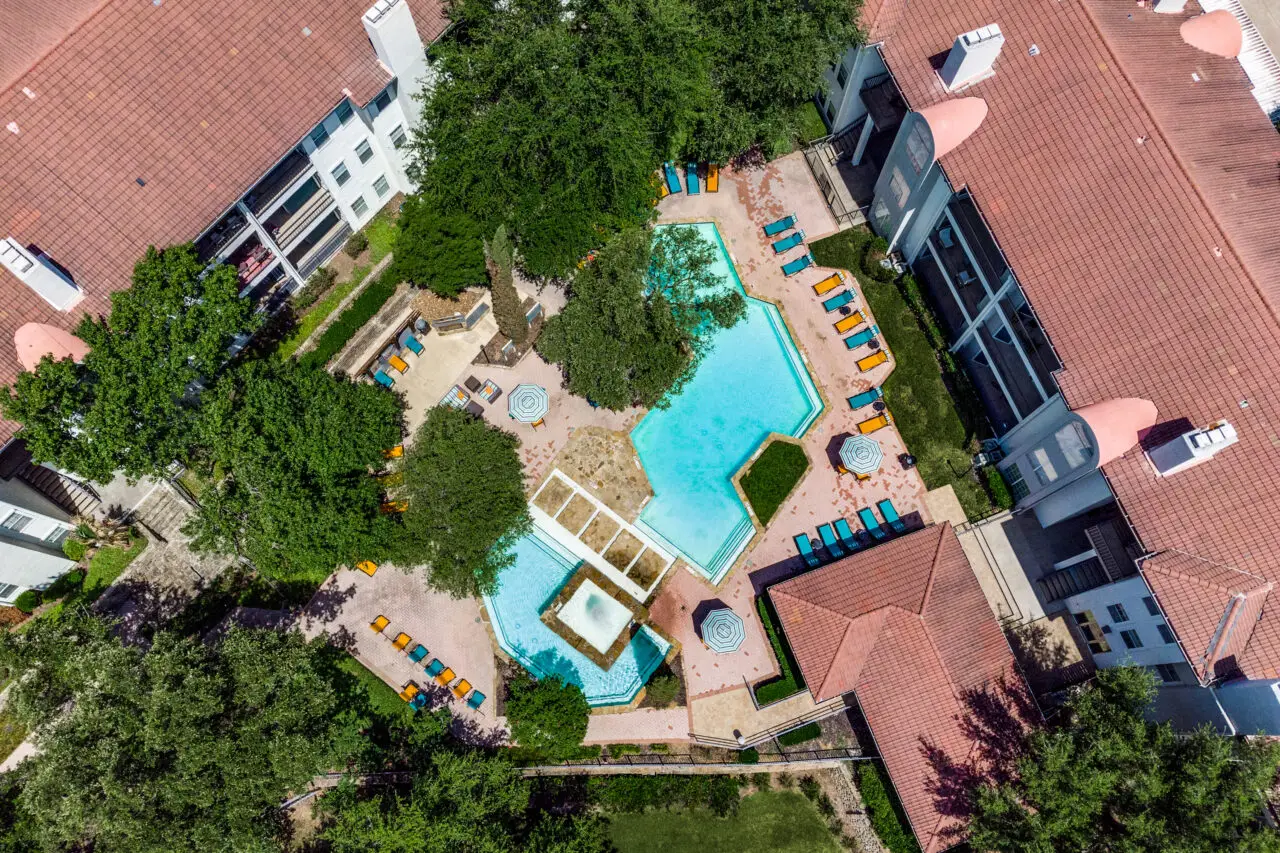birds-eye view of courtyard swimming pool with colorful lounge seating at Estates at Las Colinas